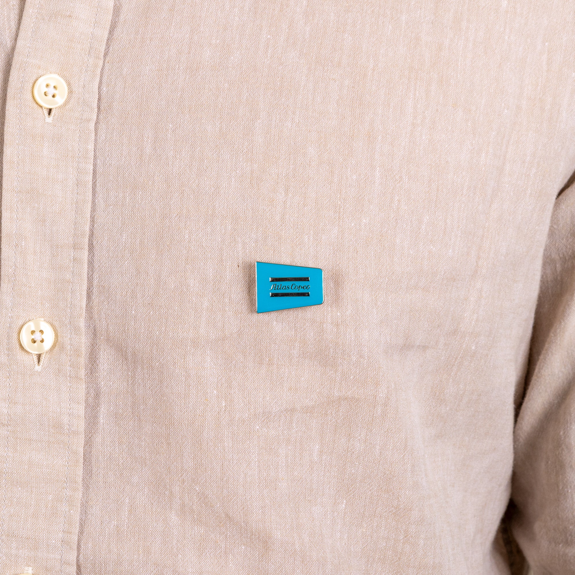 metal pin with atlas copco logo on shirt